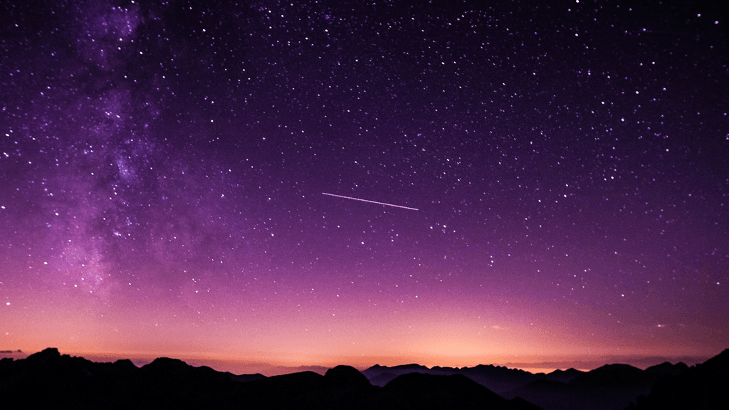 Cielo stellato con scia luminosa sopra montagne, metafora del lancio Astra