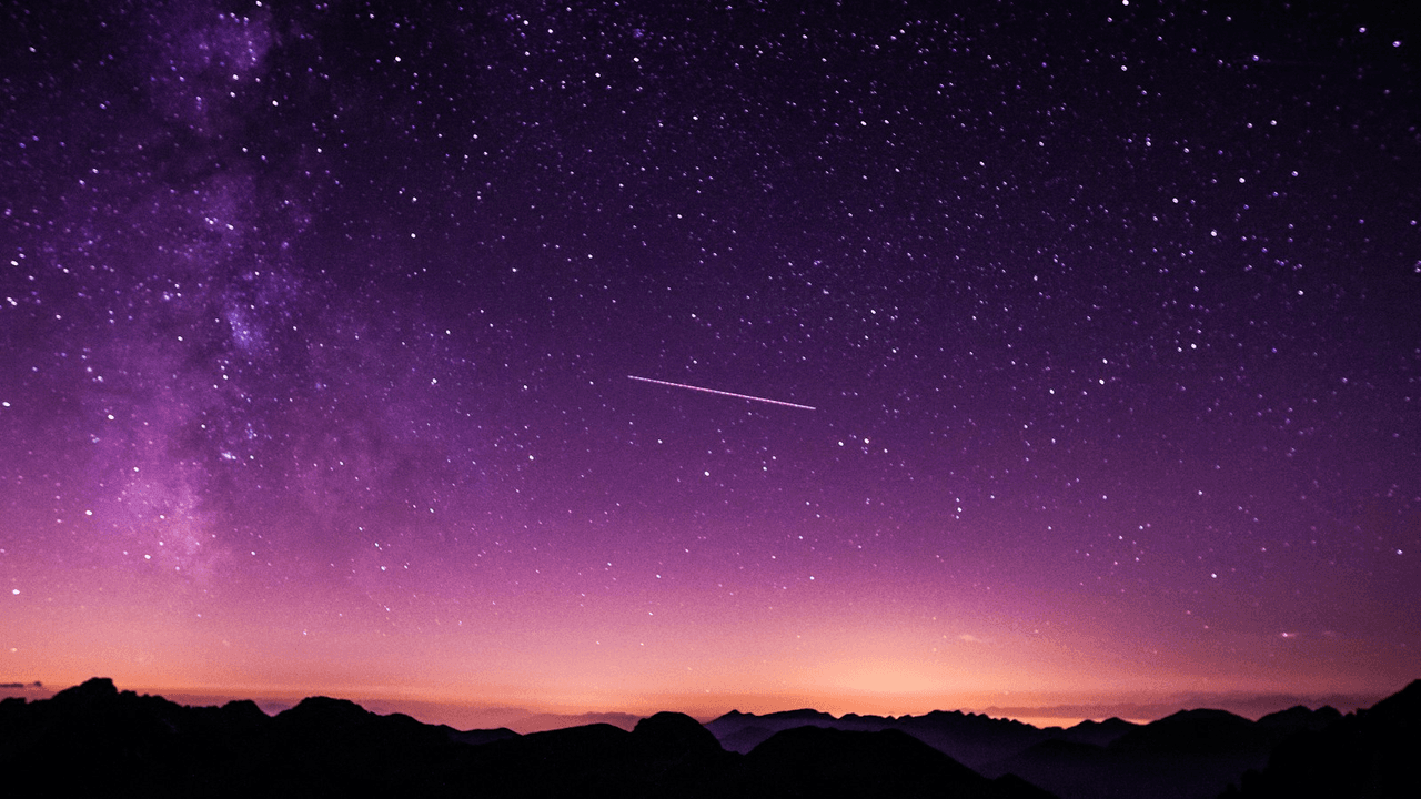 Cielo stellato con scia luminosa sopra montagne, metafora del lancio Astra